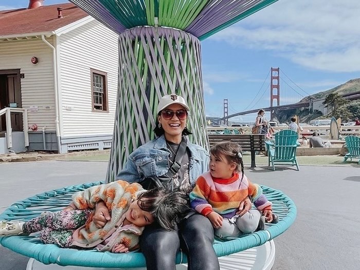 adult and two children at the bay area discovery museum with golden gate bridge in the background