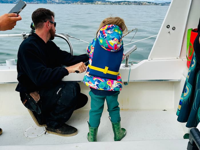 little girl fishing on boat with man on the san francisco bay