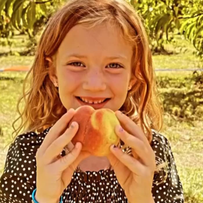 girl holding peach smiling