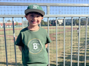 kid in Oakland Ballers merch at a baseball game