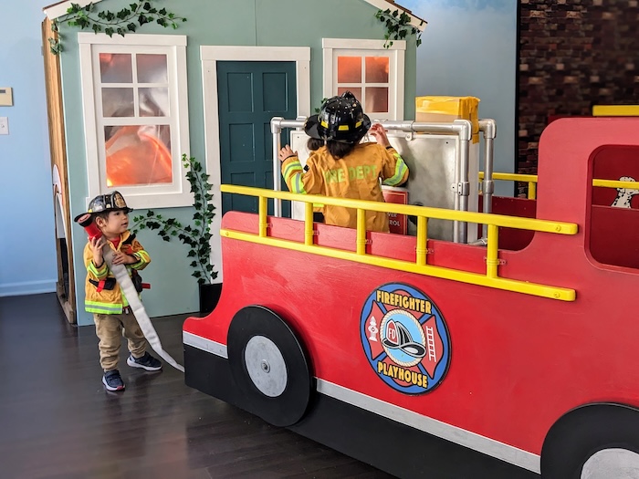 kids playing with a pretend fire engine