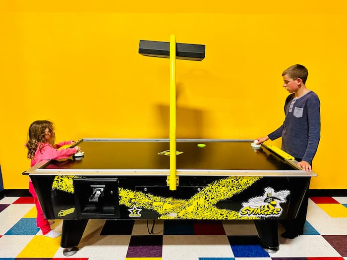 two kids playing air hockey