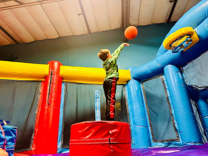boy shooting basketball into hoop