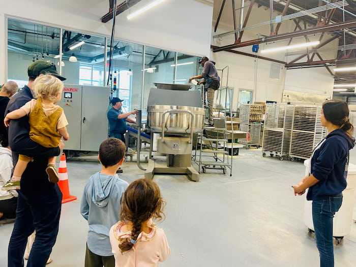 people look on as bowl at factory is prepared