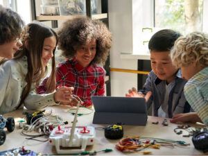 children working together on a laptop and robotics project