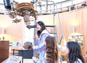 Girls looks through telescope