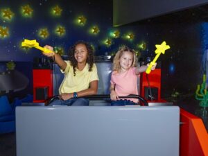 two girls on an amusement ride with magic wands at legoland milpitas