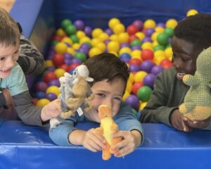 3 small children in a ball pit