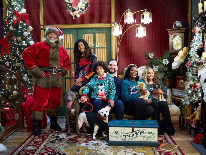black santa with a family in matching pajamas in a christmas scene