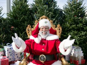 black santa claus in a beautiful setting with a golden throne christmas tree and gifts