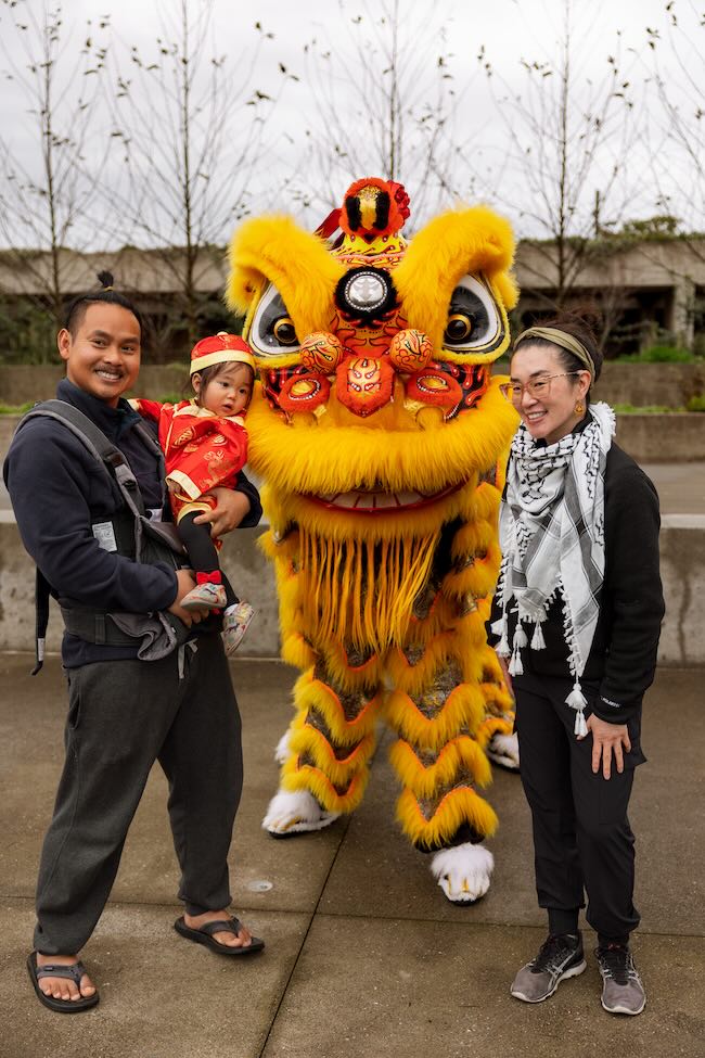 lion dancer and two adult parents and a baby