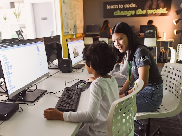 Code Coach Providing Instruction to Student at a computer station