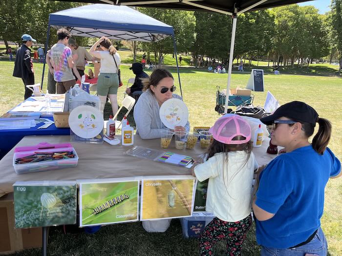 table with art project, child and two adults
