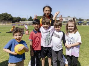 kids on a field with a counselor campers and a ball