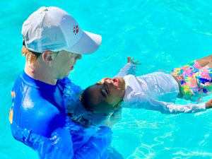 adult swimming with small child