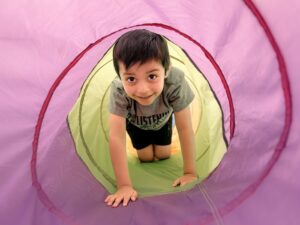 child crawling through a tunnel