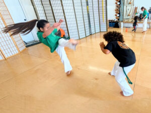 fierce girl doing a kick at United Capoeira Association - Hayward