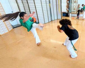 fierce girl doing a kick at United Capoeira Association - Hayward
