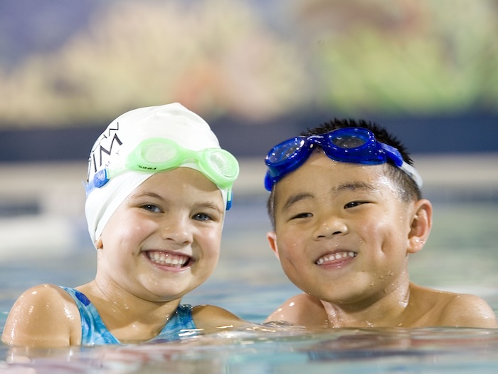 two kids with goggles on in pool