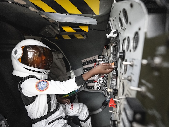 child dressed as an astronaut at a control panel