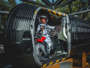 child in a flight simulator wearing a space suit