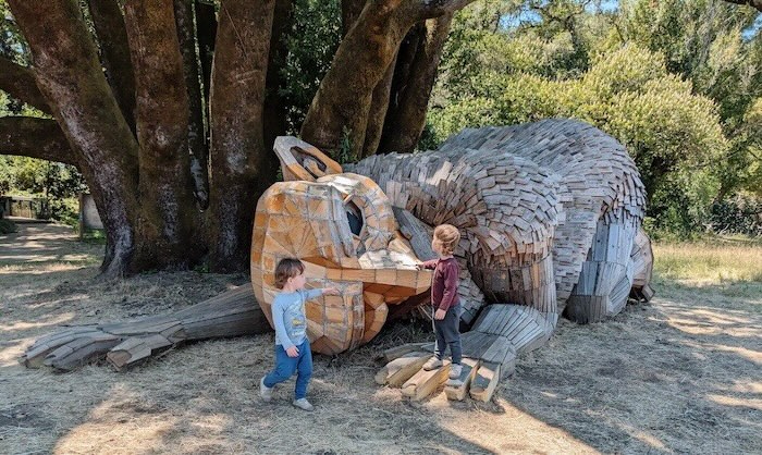 giant reclining troll and two kids exploring