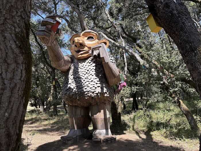giant troll hanging birdhouses in the trees