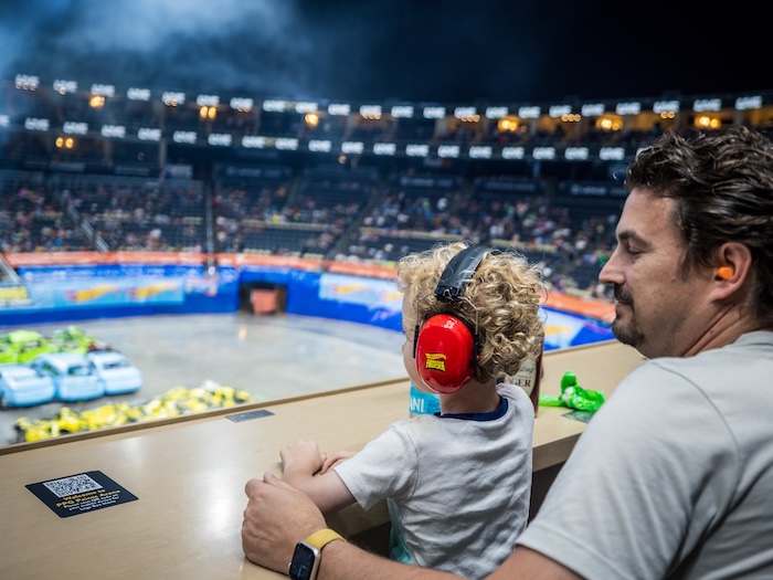parent and child watching hot wheels monster trucks