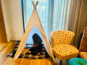child sitting in a tipi tepee teepee at the treehouse hotel