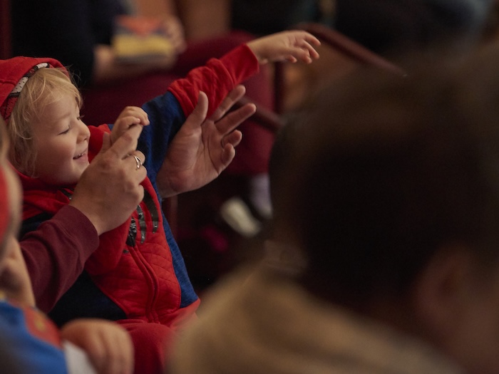 Child dressed as Spider-Man in the audience of the Symphony