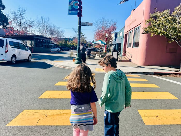 two kids walking across the street