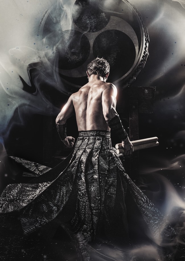 drum tao man drumming against gray backdrop