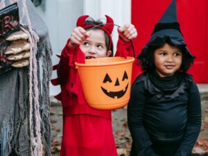 two kids near halloween decorations trick-or-treating