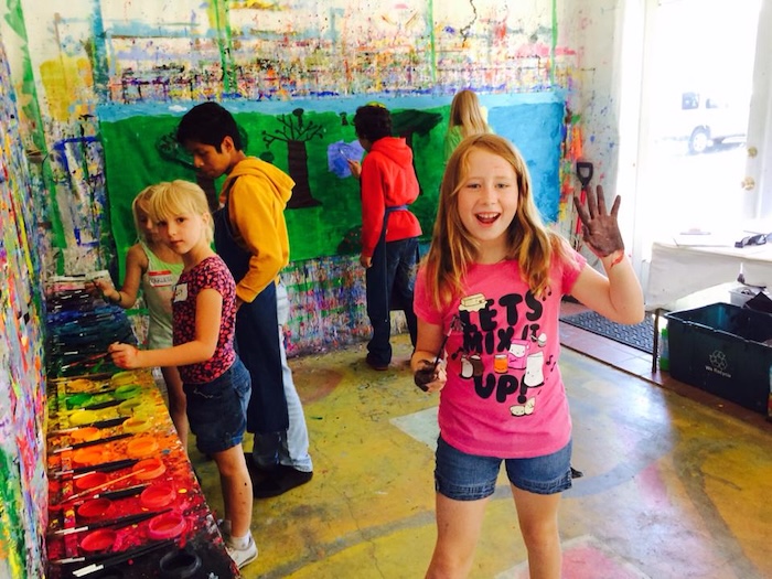 children painting on walls and canvas