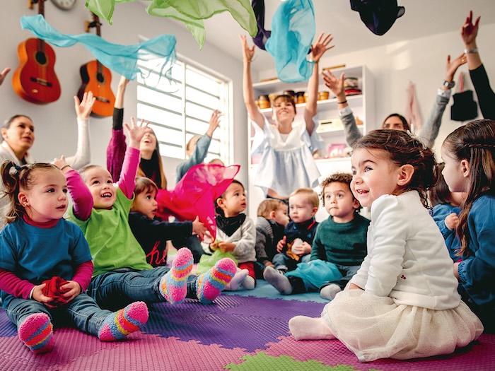 scarves flying in the air around sitting up babies with joyful parents