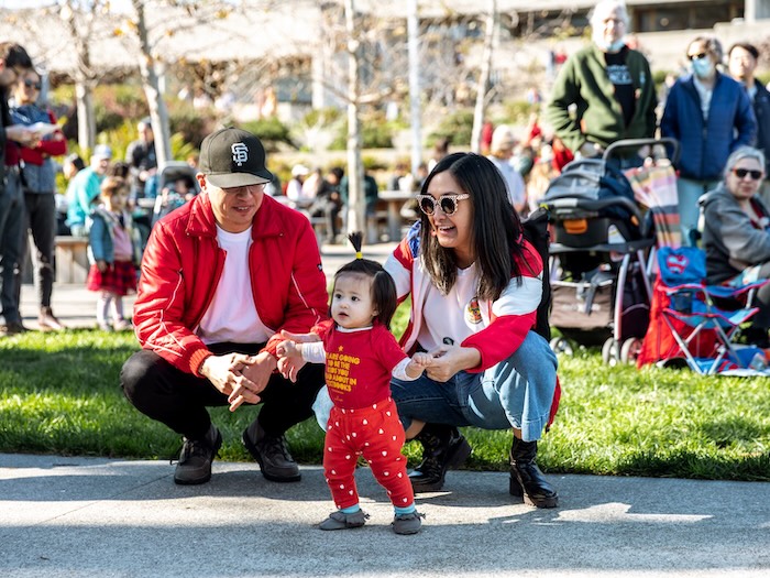 parents and small child celebrating lunar new year in a garden