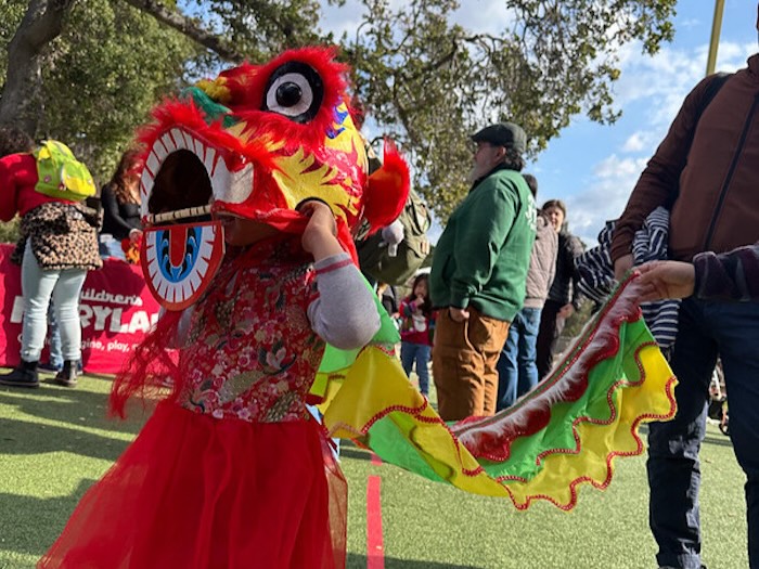 child learns how to lion dance from a teacher