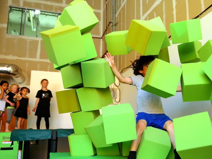 child crushing foam bocks at a parkour studio