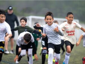 a group of soccer playing youth run and cheer