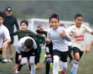 a group of soccer playing youth run and cheer