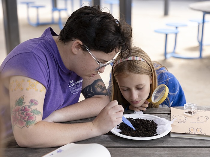 Camper and counselor looking through dirt at the lawrence stem camp
