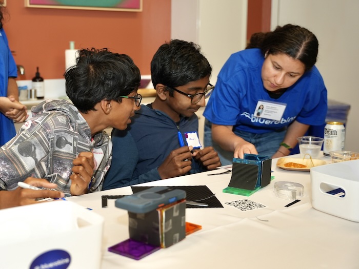 Young builders and mentors doing an electronics project together