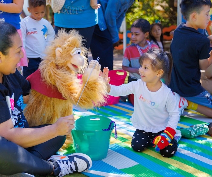 child high fives a puppet