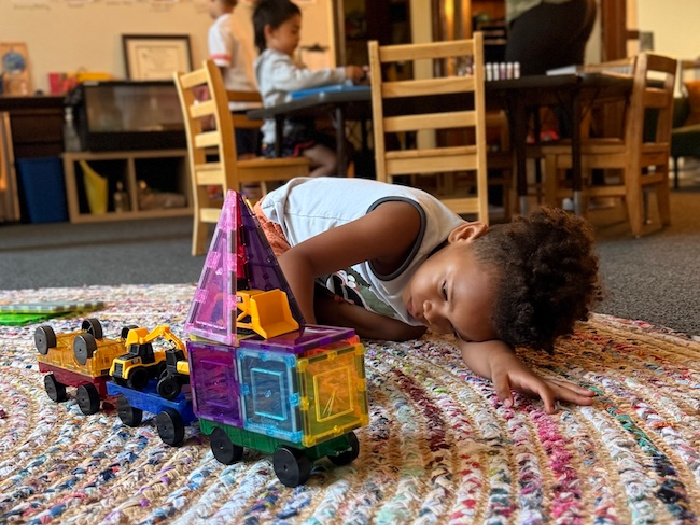 little kid builds on the carpet