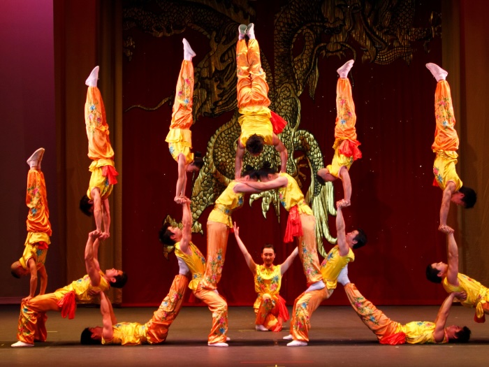 peking acrobats doing impressive feats of strength and balance on stage