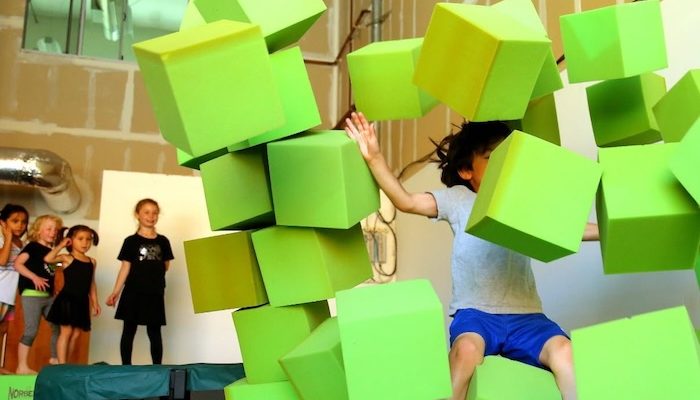 child crushing foam bocks at a parkour studio