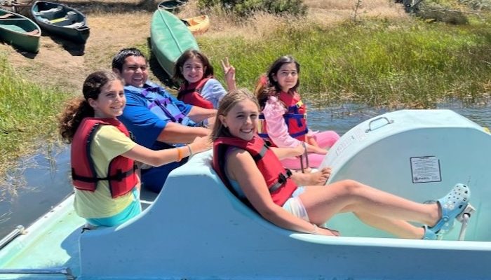 youth campers are using a pedal boat